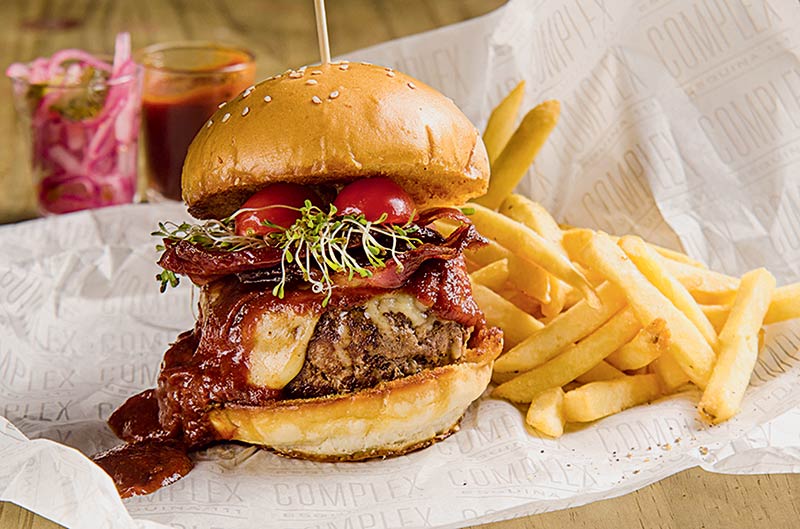 Complex Esquina 111: carne, emmental, molho barbecue, bacon glaçado, brotos e tomate (R$ 38,50)