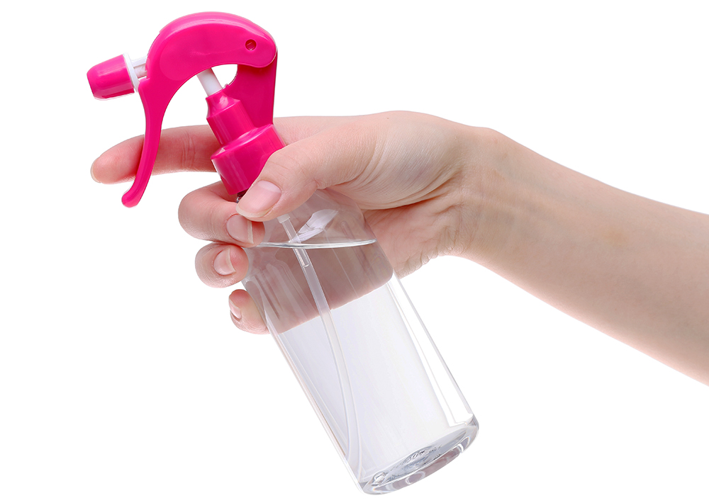 Hand holding spray perfume bottle