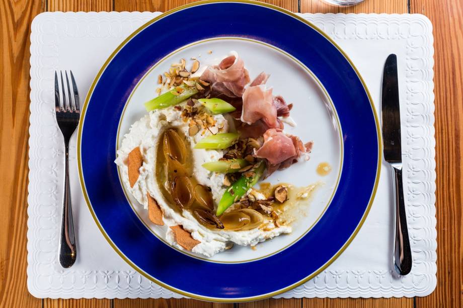 Aspargos, Parma, creme de queijo de cabra, cebola caramelada, chips de pão árabe e melado com amênodas Aspargos, Parma, creme de queijo de cabra, cebola caramelada, chips de pão árabe e melado com amênodas