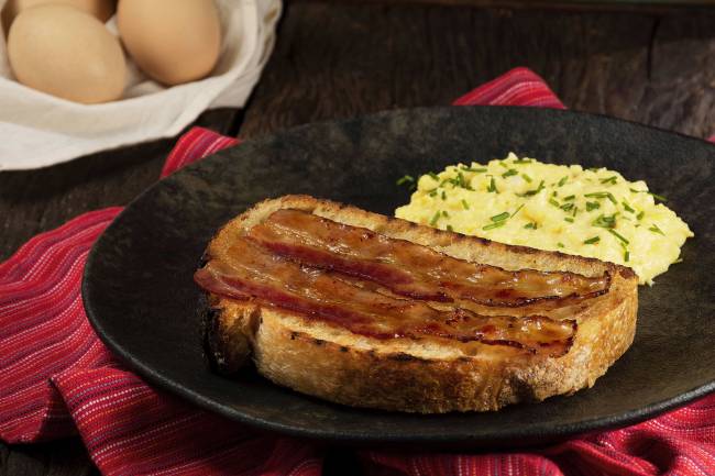 Foto Artesanos Bakery_Bongiorn 01 _fatia de sourdough com manteiga extra, ovos mexidos cremosos e bacon caramelizado_Crédito Gabriel Ávilla
