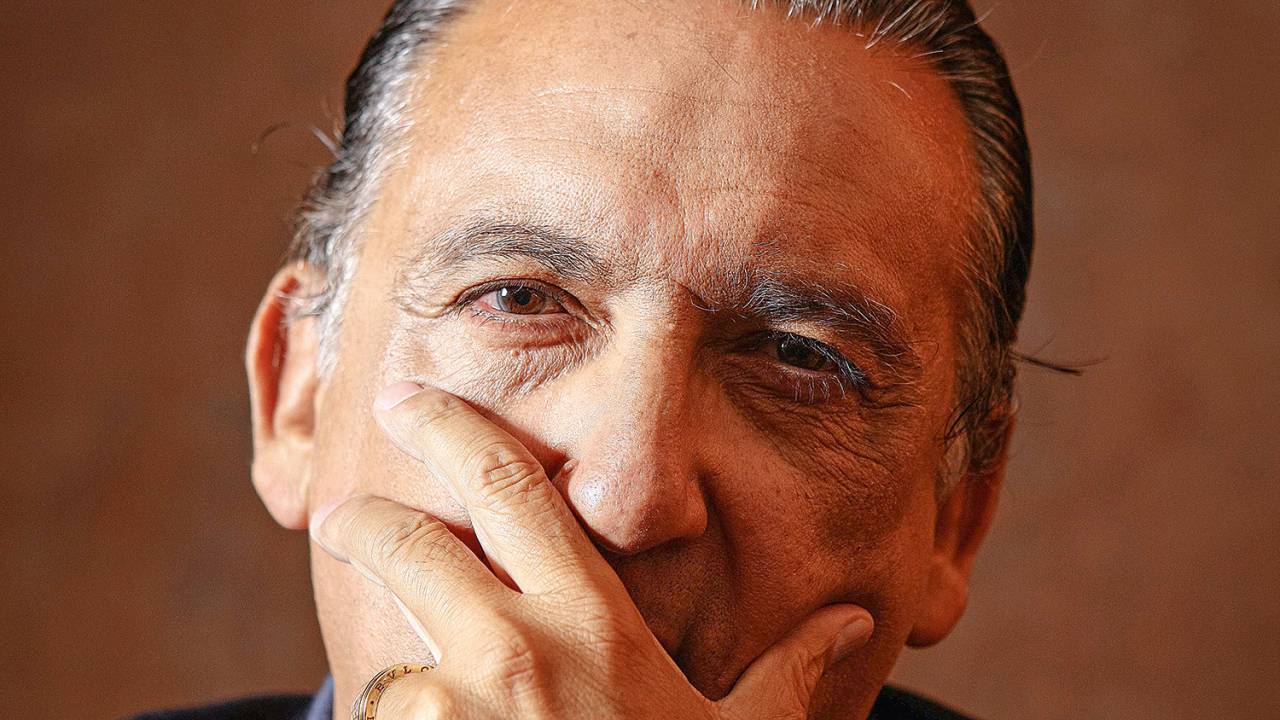 A imagem mostra o jornalista Galvão Bueno olhando para a câmera, em close, com a mão no queixo