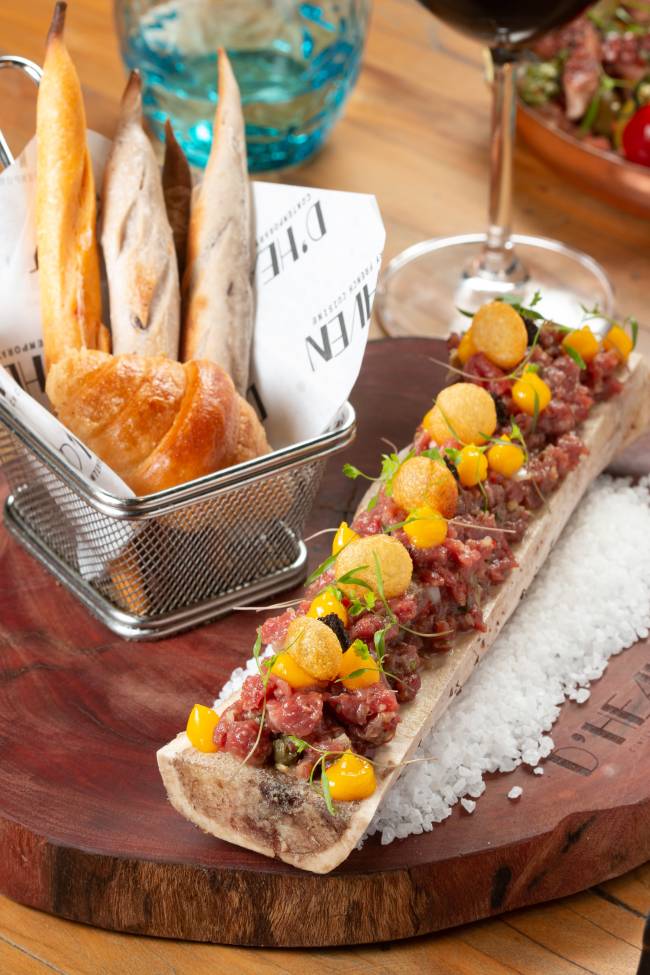 A imagem mostra um steak tartare sobre osso de tutano