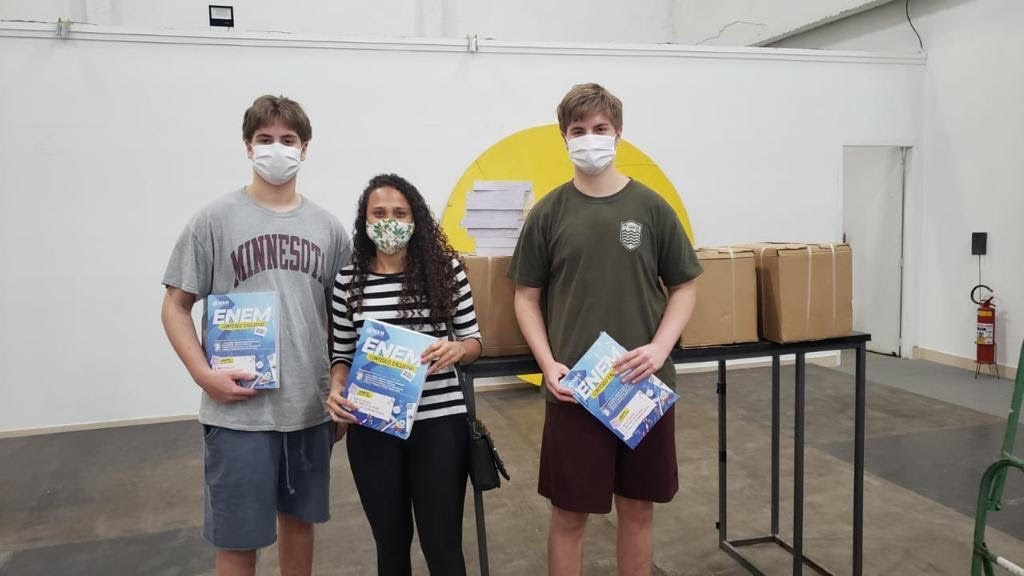 A imagem mostra dois vestibulandos segurando livros numa sala de aula