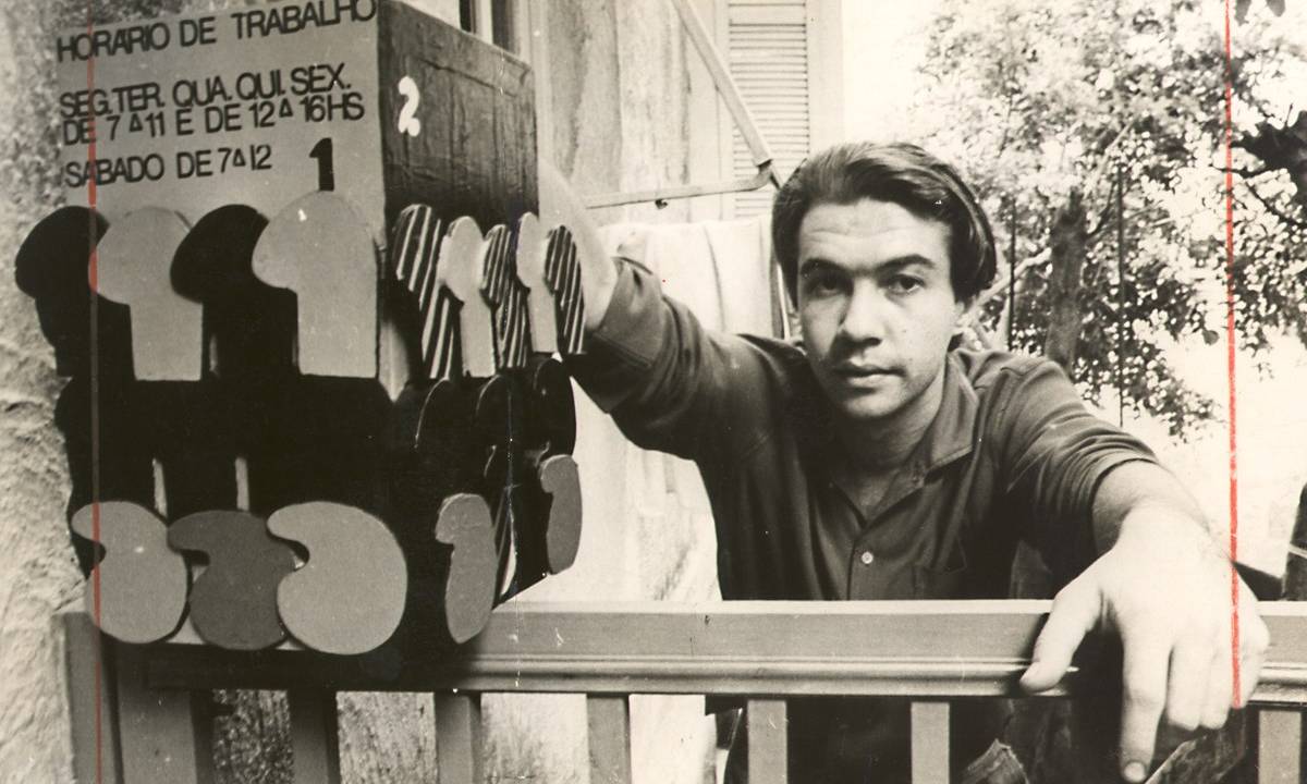 Artista Rubens Gerchman posa ao lado de obra de arte