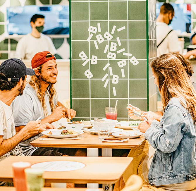 Bibi Sucos Lanchonete Bibi Sucos com clientes sorrindo e comendo nas mesas