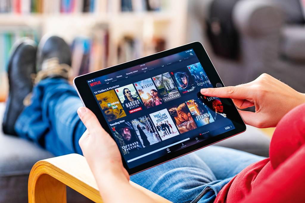 Netflix Tablet Pessoa segurando um tablet com o app da Netflix