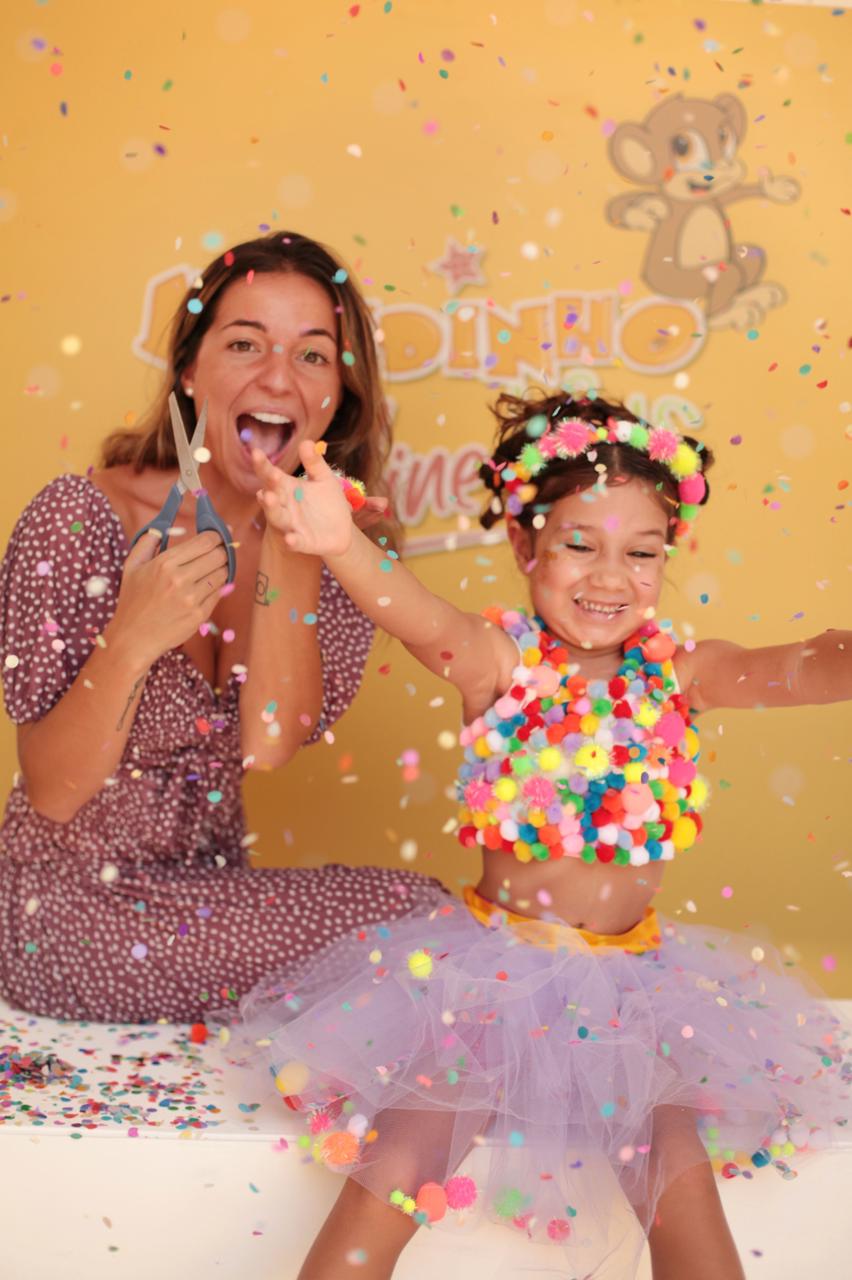 Mulher com tesoura e crian&ccedil;a fantasiada pulando