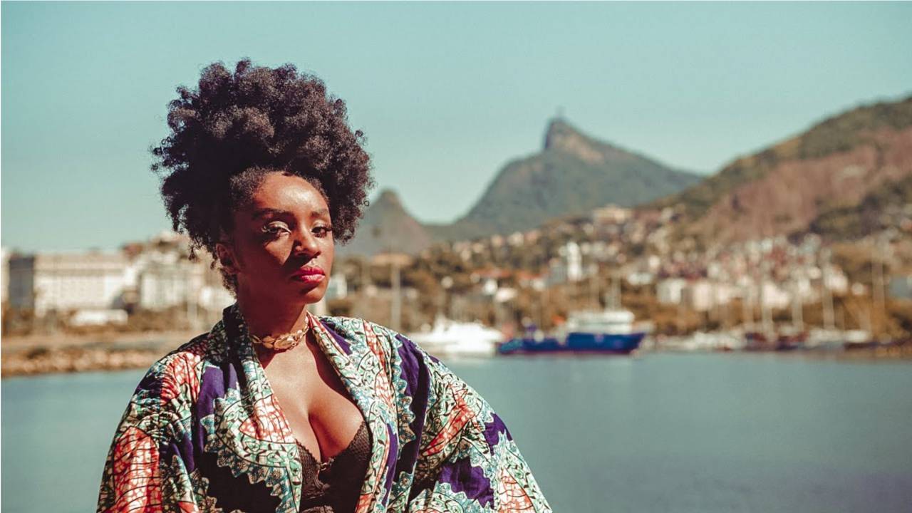 Mulher negra com paisagem do Rio atrás