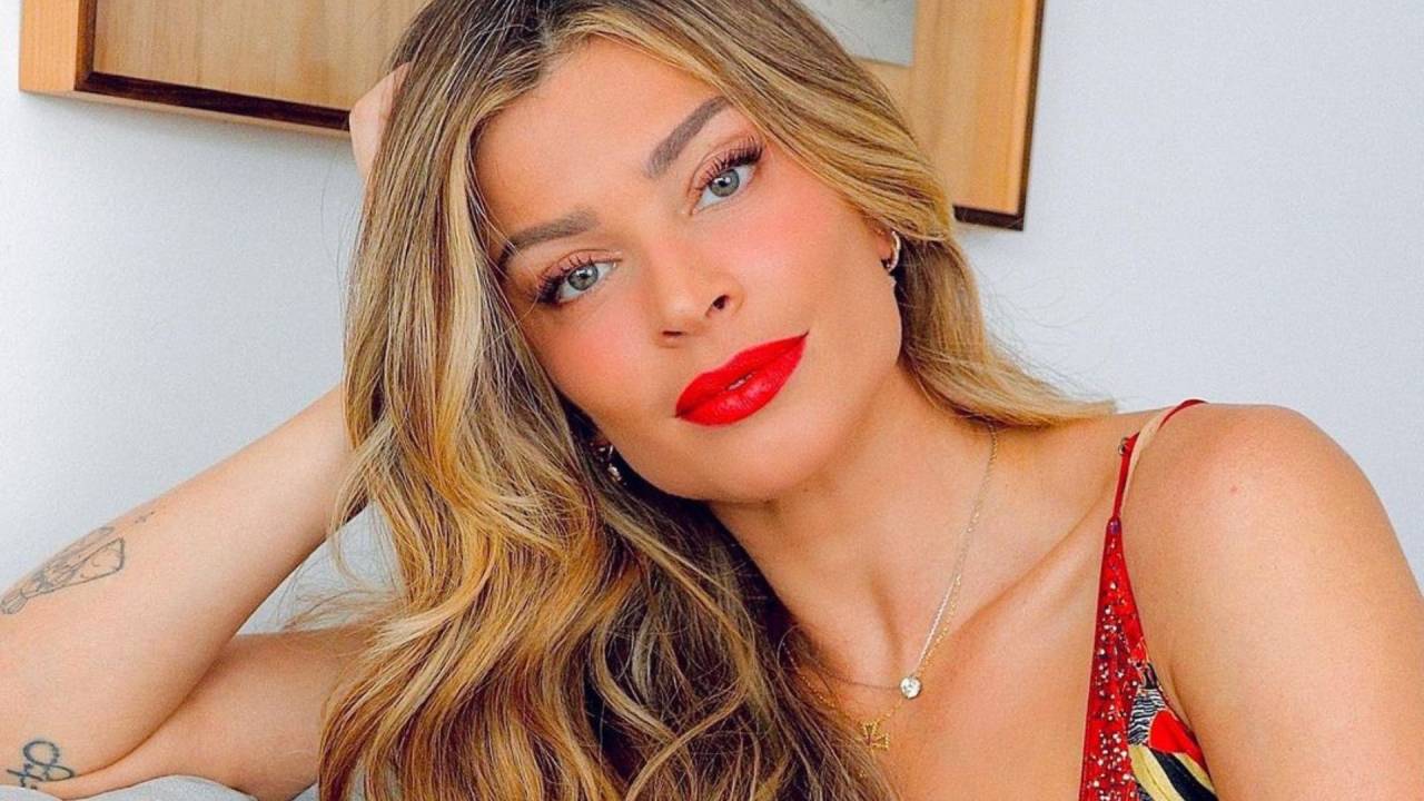 Grazi Massafera está de batom vermelho e usa blusa estampada da mesma cor