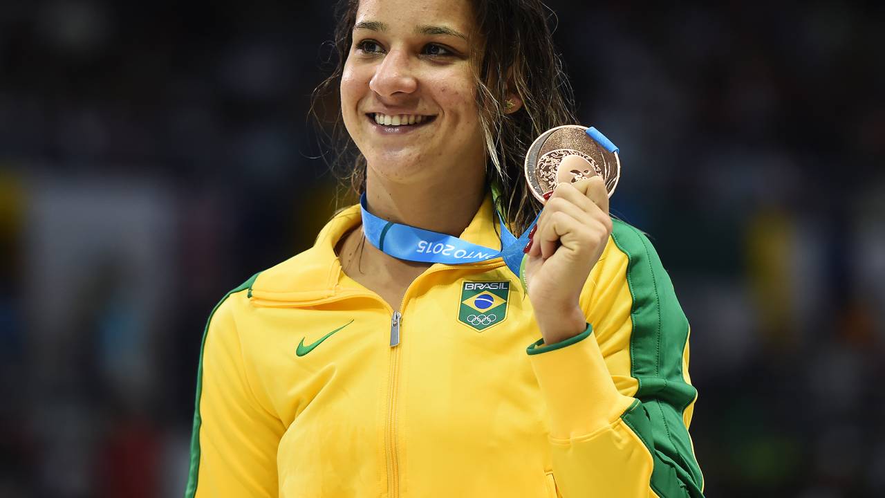 A imagem mostra Joanna Maranhão segurando uma medalha