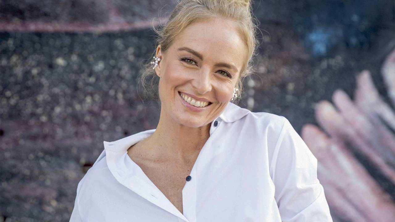 Angélica sorrindo, vestindo camisa branca