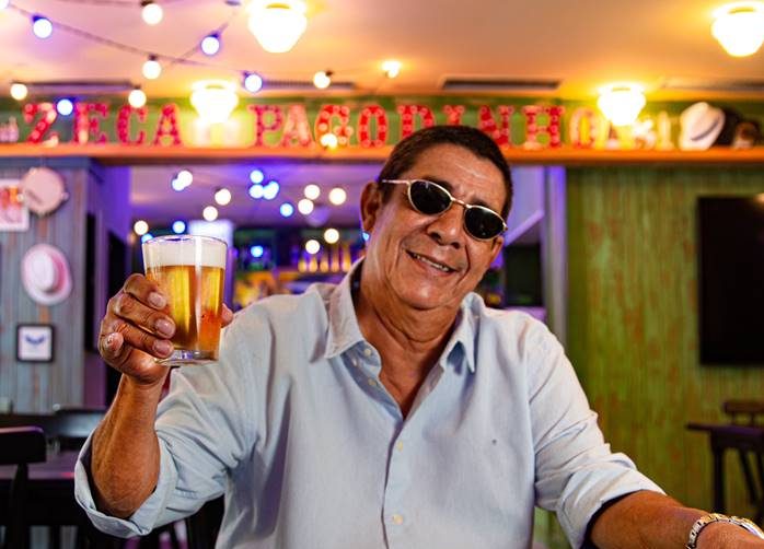 Zeca Pagodinho ergue tulipa de chope em frente ao seu bar