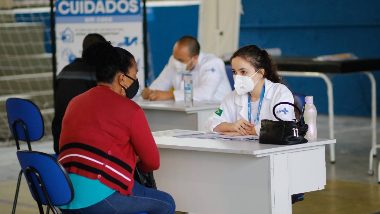 Foto mostra mulher atendendo paciente