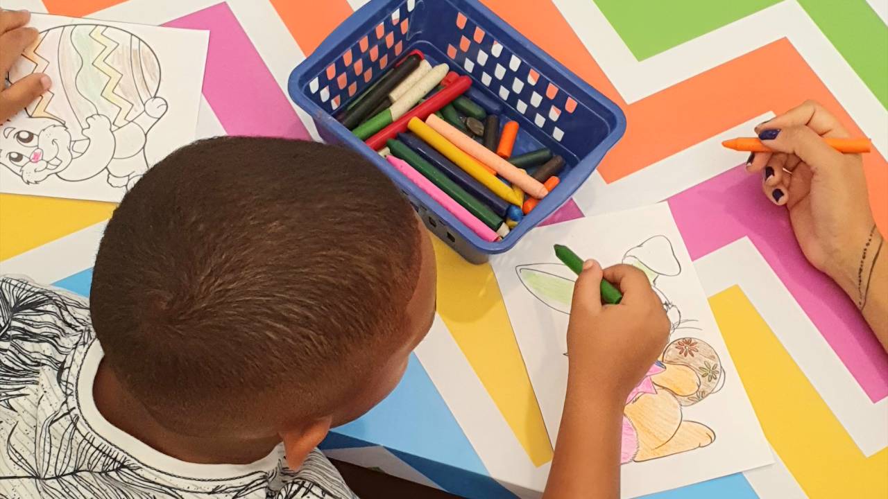 Foto mostra criança desenhando coelhinhos