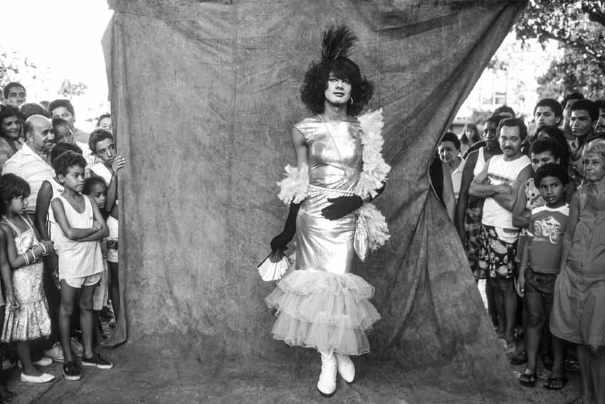 Foli&atilde;o fantasiado de mulher durante o carnaval de rua, em imagem em preto e branco.
