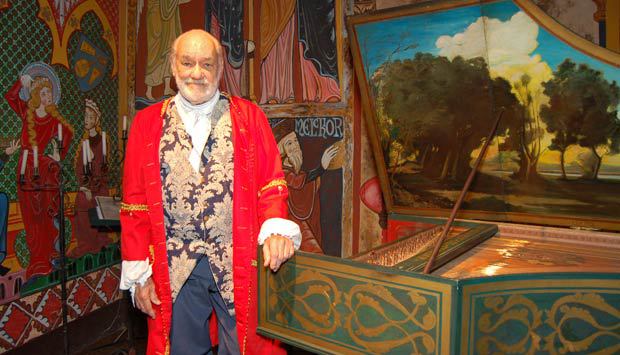Roberto de Regina com roupa de época apoiado em um cravo.