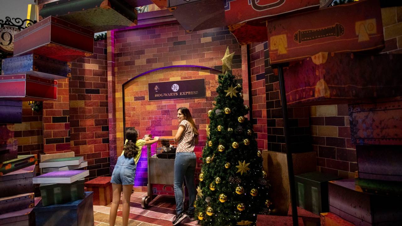 Foto mostra mãee filha tirando foto em cenário inspirado no filme Harry Potter