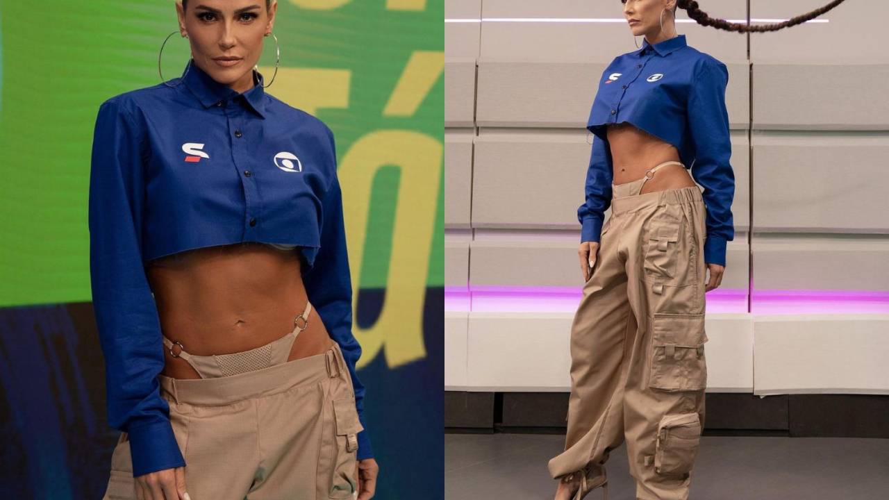 Foto mostra a atriz Deborah Secco usando camisa de botão cropped da cor azul e calça bege cintura baixa deixando a calcinha da mesma cor à mostra