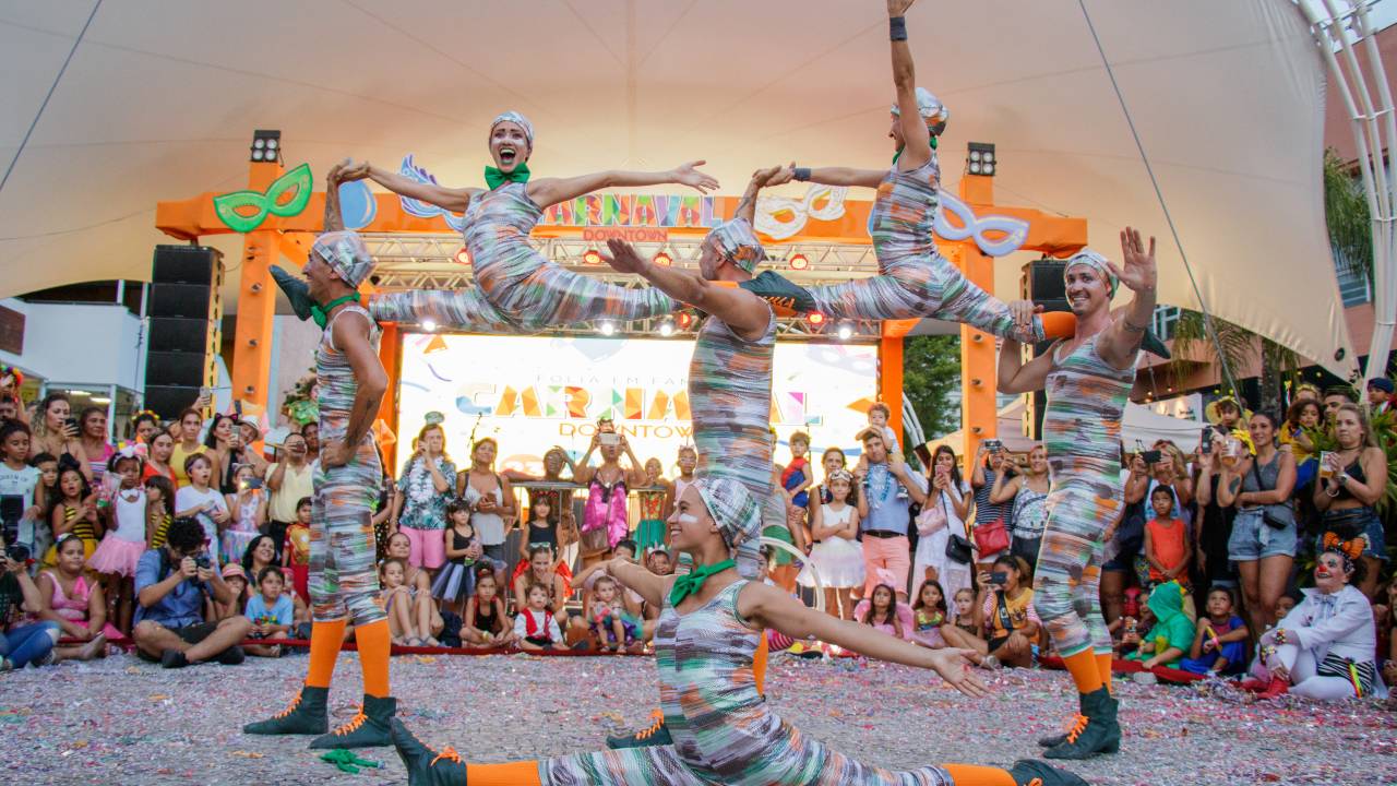 Foto mostra acrobatas de bloco de carnaval se apresentando