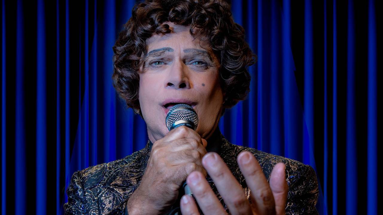 Diogo Vilela com peruca e maquiagem iguais às de Cauby Peixoto. Ele está cantando, e com uma das mãos segura o microfone, a outa está à sua frente, transmitindo emoção. Ele usava um paletó com detalhes dourados.