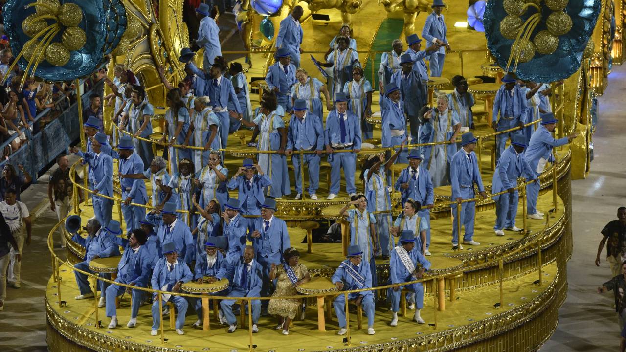 Foto mostra Velha Guarda da Portela em cima de carro dourado na Sapucaí