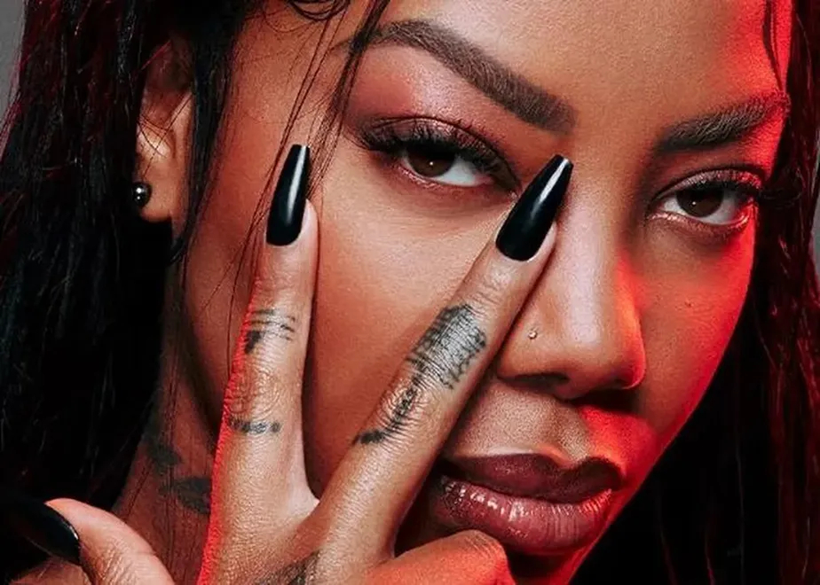 Close do rosto de Ludmilla, com dois dedos sobre o lado direito da face