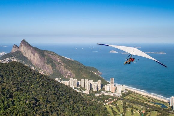 Foto mostra asa-delta sobrevoando o Rio