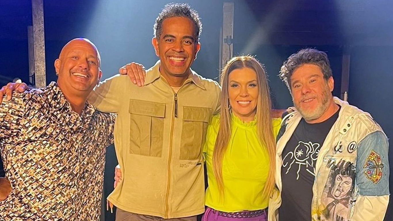 Mike (homem branco careca, com olhos castanhos, com camisa de bot&atilde;o estampada), Jairzinho (homem negro de pele clara com com olhos castanhos, de camisa bege), Simony (mulher branca com o cabelo louro e olhos castanhos) e Tob (homem branco, de olhos claros cabelo castanho clara e barba grisalha, com blusa preta e jaqueta clara).