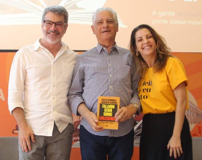Renato Caminha, Luiz Césio Caetano e Thalita Rebouças posam com o livro 