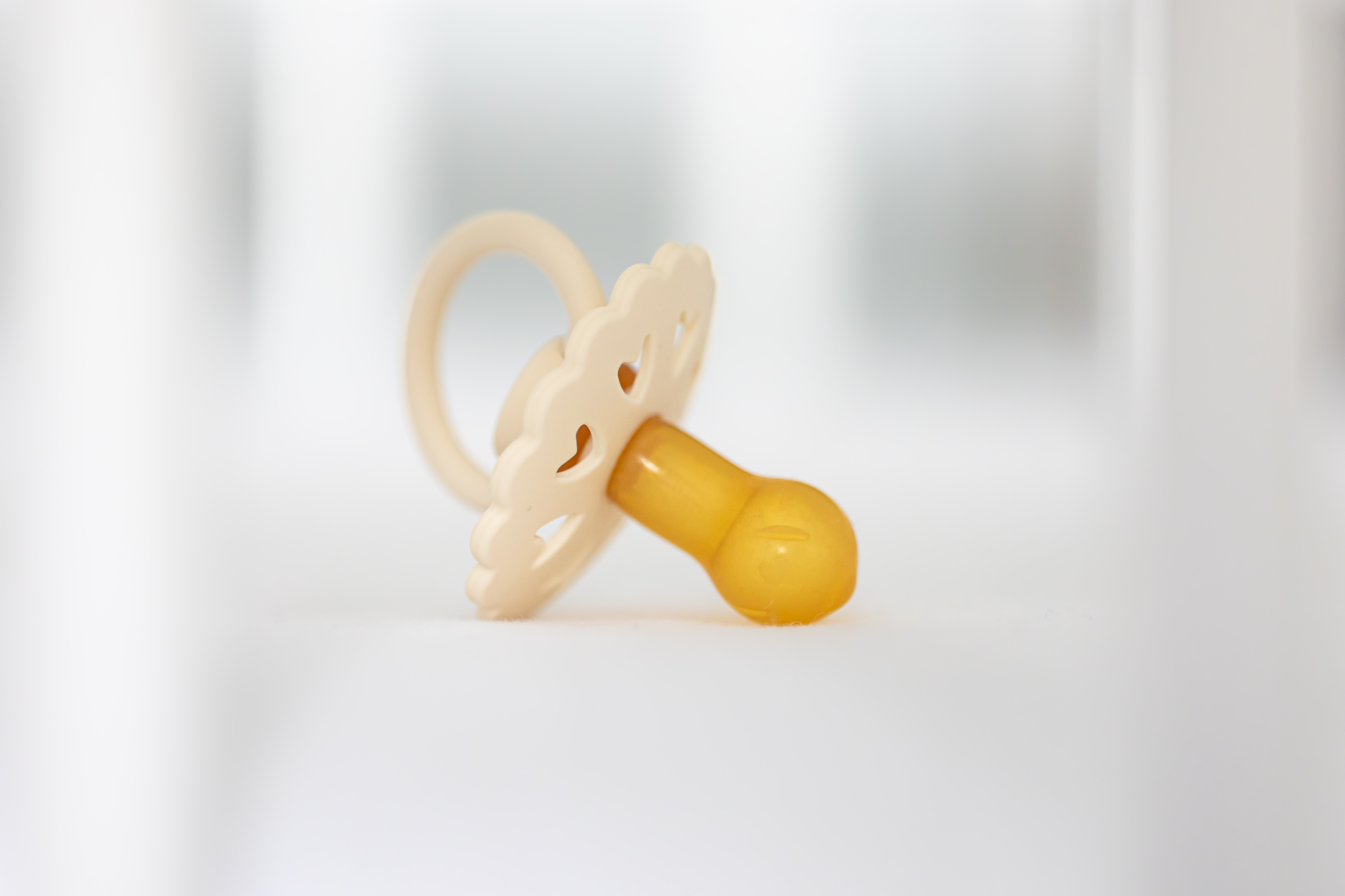 Baby’s pacifier on a blurred white background.