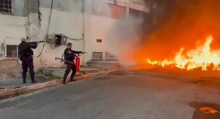 Policiais tentam conter fogo em estruturas