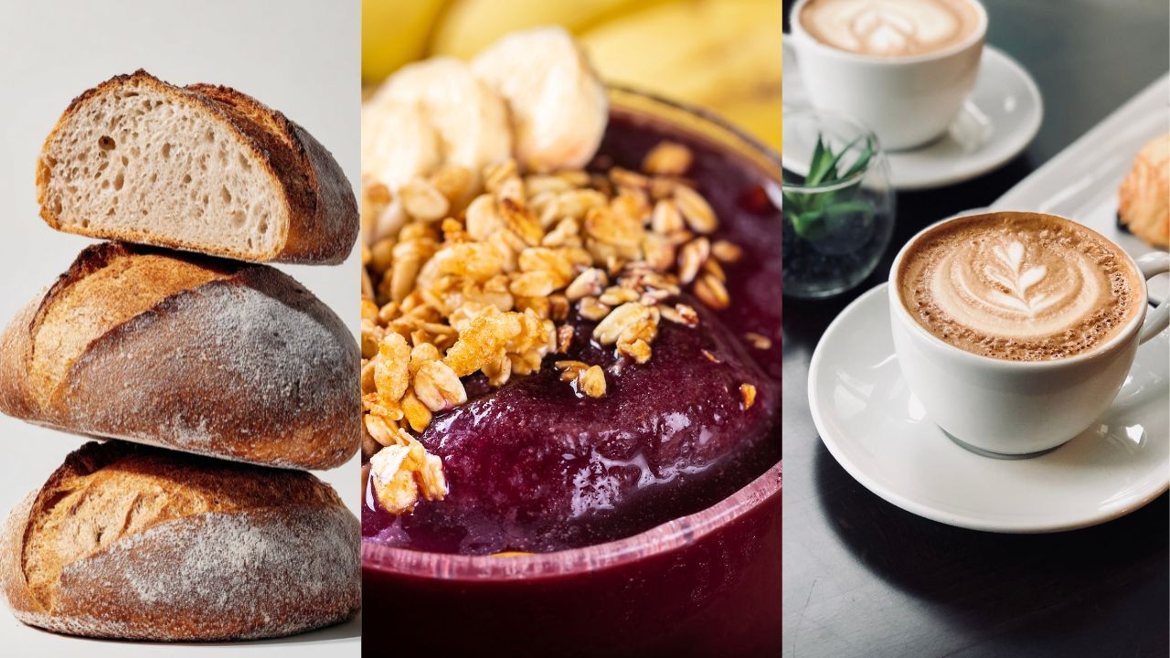 Três pães artesanais empilhados, uma tigela de açaí com granola e banana, e duas xícaras de café latte com arte na espuma, representando opções de café da manhã