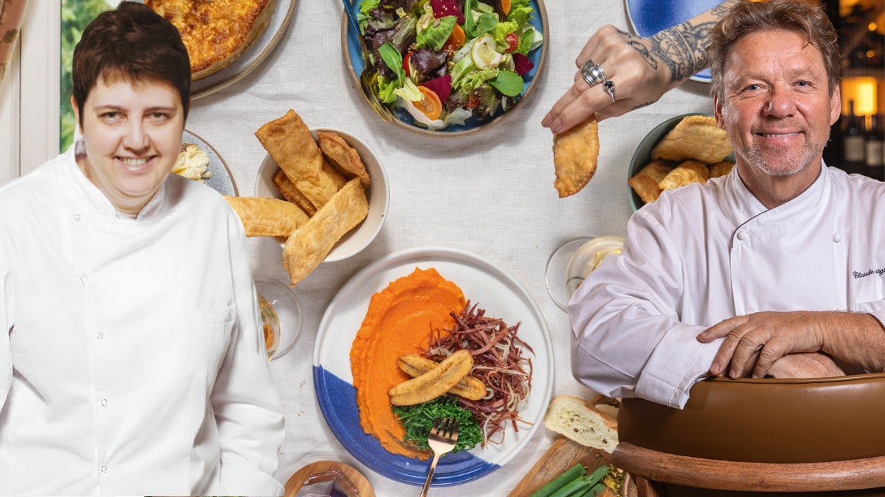 Dois chefs sorridentes, um homem e uma mulher, em aventais brancos, ladeiam uma mesa com diversos pratos: salada, torta, pastéis e purê de abóbora com banana e couve. Uma mão tatuada segura um pastel.